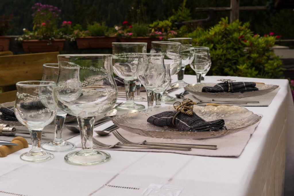 An elegantly set dining table at Alpine Garden Restaurant, featuring multiple courses including an amuse-bouche, appetizer, main course, and a cheese platter or pre-dessert, beautifully arranged to showcase the extensive and refined gastronomic experience.