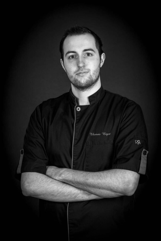 A professional portrait of Chef Thomas Bigot, showcasing his passion and expertise in the kitchen, reflecting the dedication to refined French cuisine at Alpine Garden Restaurant.